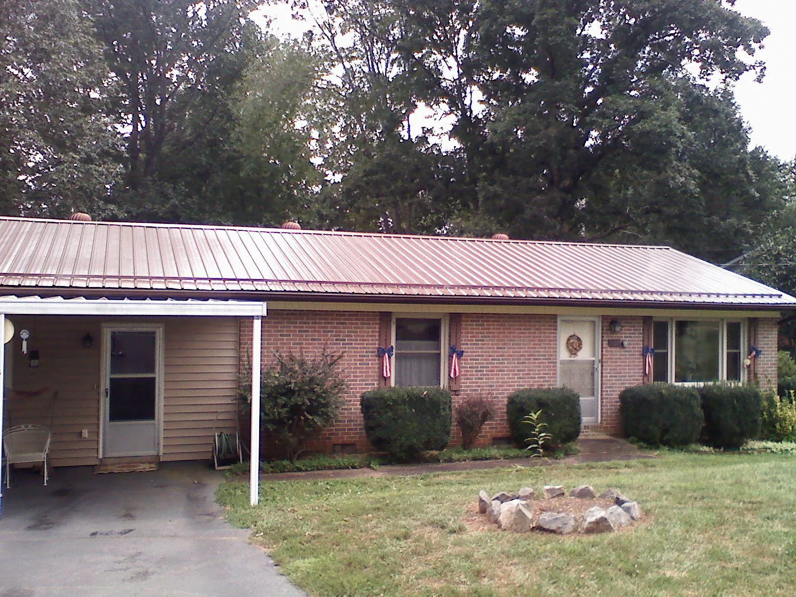 Bronze metal roof and carport on a brick ranch home — Roof Repair work by our crew in Gonzales